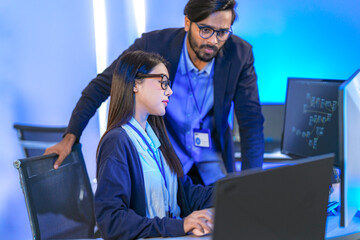 AI engineer developing algorithms in a futuristic data center. The blue light reflects innovation...