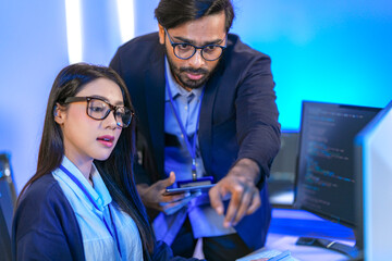 Senior engineer mentoring a junior female developer. Diverse tech team collaborating on a project,...