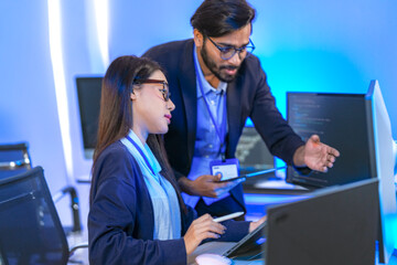 AI engineer developing algorithms in a futuristic data center. The blue light reflects innovation...