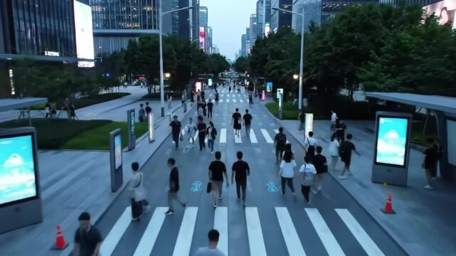 An elevated perspective showcases a bustling pedestrian crossing during the evening, with illuminated crosswalk lines and surrounding buildings creating a vibrant urban scene.