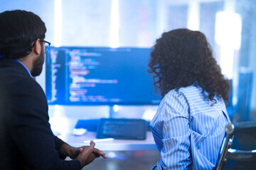 Diverse software developers in a lively discussion about a project. A male and female colleague...
