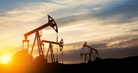The change in oil prices caused by the war. Oil price cap concept. Oil drilling derricks at desert...