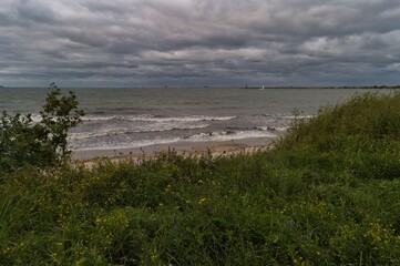 Calm waves and overcast skies along a tranquil beach at dusk near the shoreline