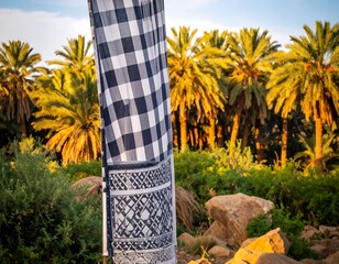 Checkered flag in palm grove at sunset