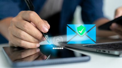 Businessman using a laptop and smartphone with a hologram showing OTP authentication and secure email login. Concept of two-factor authentication, cybersecurity, and data protection technology.