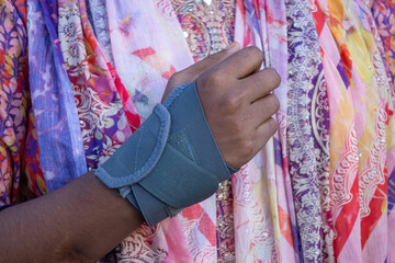 Close-up of a female hand with a wrist and thumb brace, a universal support suitable for both men...