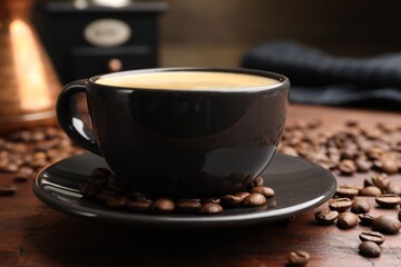 Aromatic coffee in cup and beans on wooden table, closeup