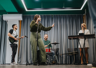 Music band practicing together in a studio setting with professional equipment