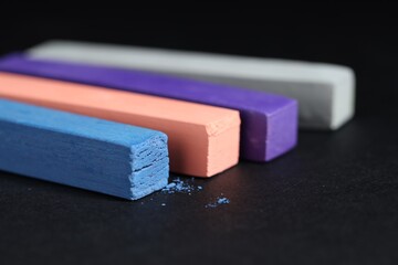 Colorful chalk pastels on black background, closeup