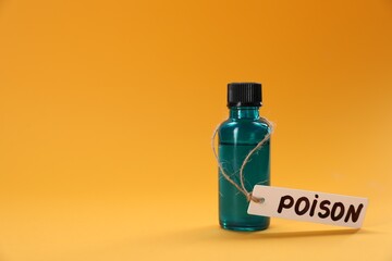 Bottle of poison on orange background, space for text