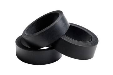 Close-up of three black rubber rings/bands stacked.  Dark background