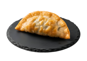 A crispy, golden-brown fried dumpling, showcasing a delicious, savory filling, sits on a dark stone plate against a black background.