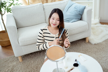 Young Asian woman doing makeup her face at home