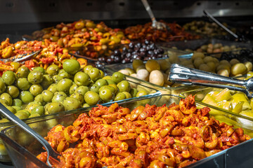 Fresh olives in vibrant colors displayed at a market, showcasing healthy food options with a...