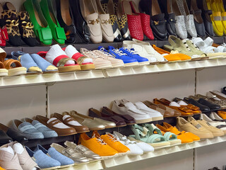 Shelves of shoes in multiple styles, colors and designs displayed in a store. Fashion, consumer...