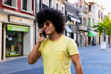 Young man walking down the street talking on smartphone