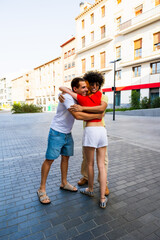 Happy friends embracing in a city street: showing affection and joy