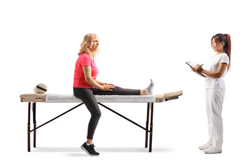 Obraz premium Physical therapist in a white uniform holding a clipboard and talking to a woman with leg injury
