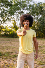 Fototapeta premium Young man showing thumbs up in a park