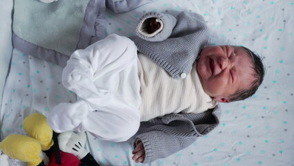Newborn baby stretching and crying, showcasing the raw emotions and physical expressions of early...