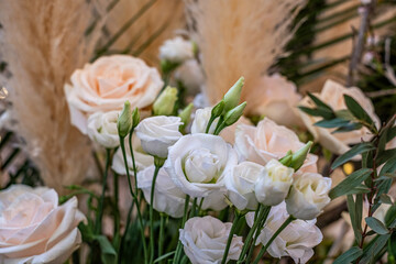 Elegant arrangement of soft white roses and delicate greenery, featuring textured pampas grass, creating a chic and inviting atmosphere for modern wedding decoration
