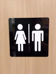 Male and Female Restroom Sign on a Wooden Door