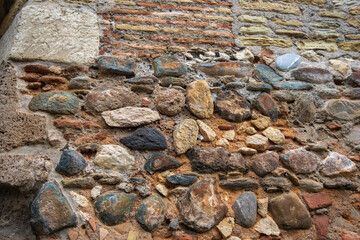 Explore the ancient stone wall of La Alhambra Spain, featuring a mix of colorful rocks and bricks...