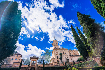 Historic Partal Palace tower at Alhambra complex in Granada Spain against dramatic blue sky with...