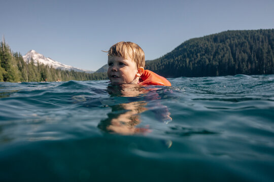 A young toddler swims in an alpine lake in the Pacific Northwest.