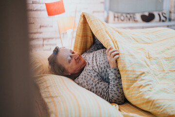 A cozy scene of a senior woman relaxing under a warm blanket in a comfortable home environment, evoking warmth and tranquility.