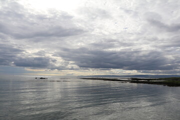 Icelandic coastline with calm ocean and moody clouds 