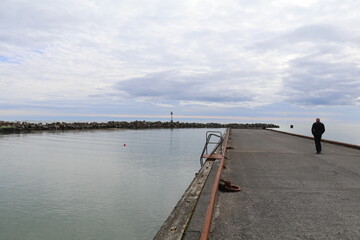lonely person on an empty quay on the Icelandic coast walking towards the ocean