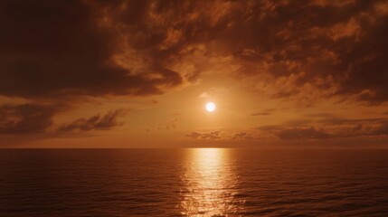 A stunning sunset over the ocean with golden hues reflecting on calm waters, creating a serene and picturesque scene.