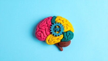 This conceptual image features a stylized brain crafted from colorful modeling clay, segmented into exaggerated lobes using vivid hues—red, yellow, green, orange, and purple. 