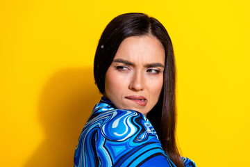 Stylish young woman with an expressive look in a vibrant outfit posing against a bold yellow background