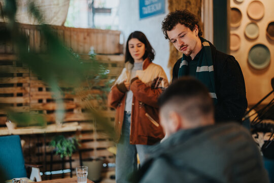 A group of young people enjoying a relaxed conversation in a warm cafe. Showcasing a casual and friendly environment, emphasizing togetherness and social interaction in a comfortable urban setting.