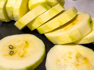 Sliced green zucchini on a kitchen board