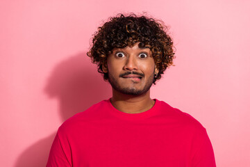 Fototapeta premium Young man in vibrant attire expressing surprised emotions against a pink background during a promotional shoot