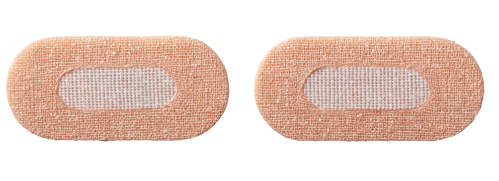 Two light beige, oval-shaped medical adhesive bandages with a centered,  translucent fabric patch