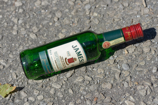 empty discarded bottle of Jameson Triple Distilled Irish Whiskey on the ground