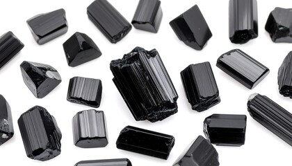 Black mineral crystals scattered on a white background.  Rough,faceted pieces