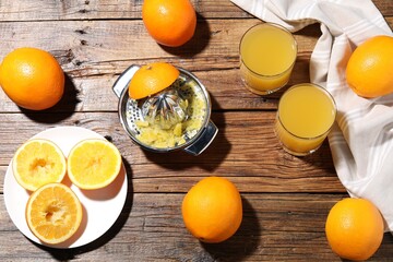 Freshly squeezed orange juice, fruits and juicer on wooden table, flat lay