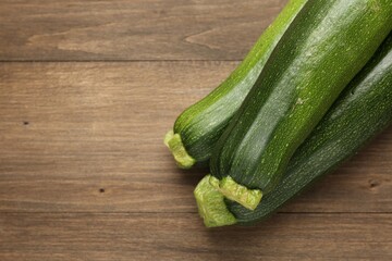 Fresh ripe zucchinis on wooden table, top view. Space for text