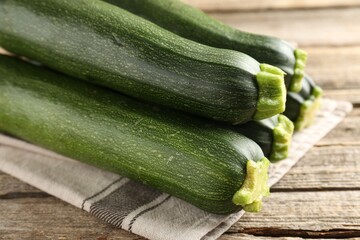Fresh ripe zucchinis on wooden table, closeup