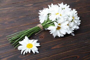 Bouquet of beautiful chamomile flowers on wooden table, closeup