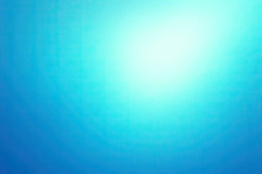 Serene abstract background with a radiant aqua to deep blue gradient, featuring a bright, ethereal glow from the upper right corner, creating a tranquil and smooth textured visual for various design p