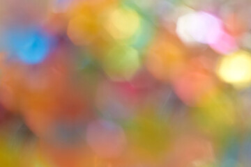Colorful abstract bokeh background with rainbow light effects and soft blurred circles.
