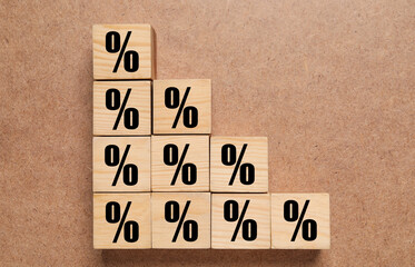 Wooden cubes with percent signs on brown textured background, top view