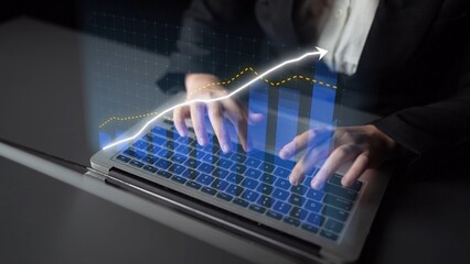 A professional individual types on a laptop while analyzing financial data and growth trends, showcasing modern technology in a sleek office environment. Copula