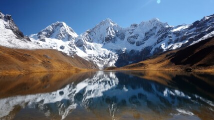Obraz premium Breathtaking snowy mountains reflected in a still alpine lake, sharp peaks with thick ice, golden-brown hillsides,